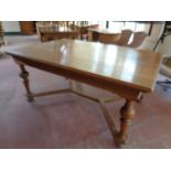 A late 19th century oak dining table on turned legs with under stretcher