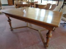 A late 19th century oak dining table on turned legs with under stretcher