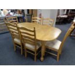 A contemporary pine pull out dining table together with six ladder back chairs