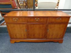 A Strong Bow Furniture inlaid yew wood triple door sideboard fitted two drawers