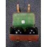 A pair of wooden lawn bowls in Spalding bag