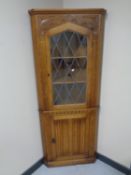 A good quality carved oak leaded glass door corner unit