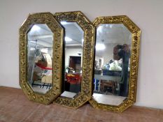 Three 20th century octagonal brass embossed framed bevel edged mirrors
