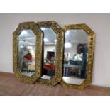 Three 20th century octagonal brass embossed framed bevel edged mirrors