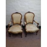 A pair of early 20th century French walnut salon armchairs