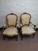 A pair of early 20th century French walnut salon armchairs
