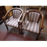 A pair of wood framed tub chairs upholstered in a striped fabric
