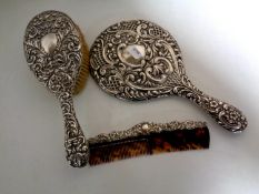 A three piece silver backed and edged dressing table brush,