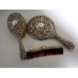 A three piece silver backed and edged dressing table brush,