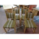 A set of five blonde oak dining chairs upholstered in a green striped fabric