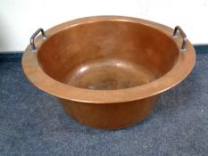 An antique copper twin handled cooking pot,