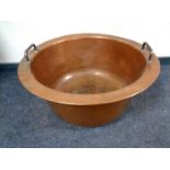 An antique copper twin handled cooking pot,