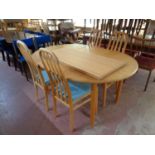 A circular pine extending dining table with two leaves together with a set of four rail back chairs
