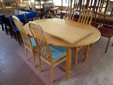 A circular pine extending dining table with two leaves together with a set of four rail back chairs