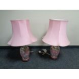 A pair of pink glazed ceramic table lamps depicting storks,