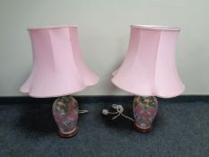 A pair of pink glazed ceramic table lamps depicting storks,