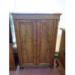 A 19th century continental burr walnut double door cabinet on bun feet