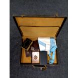 A leather case containing Freemason's badge and apron,