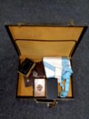 A leather case containing Freemason's badge and apron,