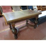 An early 20th century oak pull out dining table on bulbous legs
