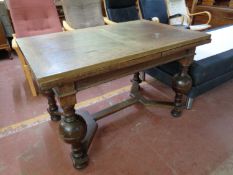 An early 20th century oak pull out dining table on bulbous legs