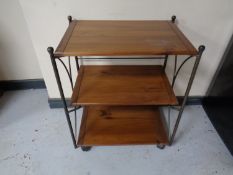 A contemporary wrought iron and pine three tier tea trolley