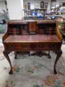 A reproduction mahogany Carlton House style writing desk with a leather inset panel on claw and
