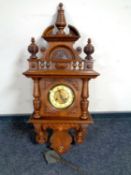 An antique continental walnut cased wall clock with pendulum and key