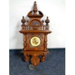 An antique continental walnut cased wall clock with pendulum and key