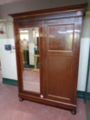 An antique mahogany double door wardrobe