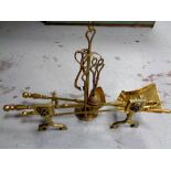 A pair of antique brass fire dogs together with three companion pieces,