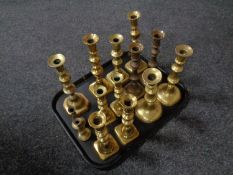 A tray containing antique brass candlesticks