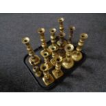 A tray containing antique brass candlesticks