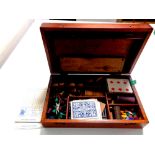 An Edwardian mahogany games box containing drafts, counters, cards,