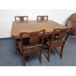 An early 20th century carved oak pull out dining table on bulbous legs together with a set of four