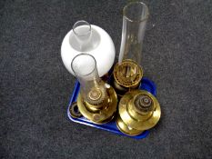 Four 20th century oil lamp bases, three with chimneys,