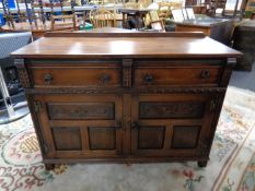 A carved oak double door sideboard fitted two drawers