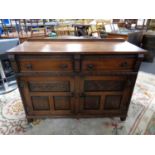 A carved oak double door sideboard fitted two drawers