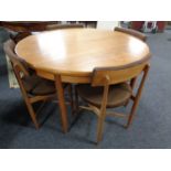 A 20th century circular teak G Plan dining table with four stowaway chairs