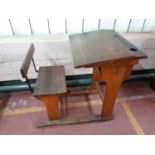 A mid 20th century school desk with chair