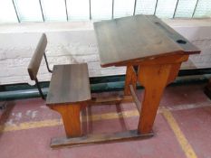 A mid 20th century school desk with chair