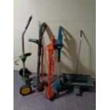 Three assorted garden strimmers together with a seed spreader