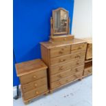 A pine six drawer chest with dressing table mirror together with matching three drawer bedside