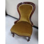 A Victorian mahogany framed lady's chair upholstered in a gold dralon