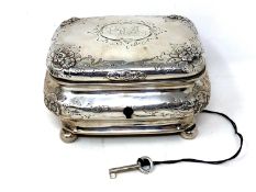 A 19th century German silver tea caddy, coat of arms to lid, on ball feet, original silver key.