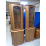 A pair of contemporary glazed door corner cupboards,