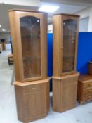 A pair of contemporary glazed door corner cupboards,