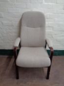 A stained beech high backed armchair upholstered in a grey fabric