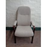 A stained beech high backed armchair upholstered in a grey fabric