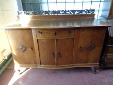 An early 20th century continental oak shaped front four door sideboard with carved rail back